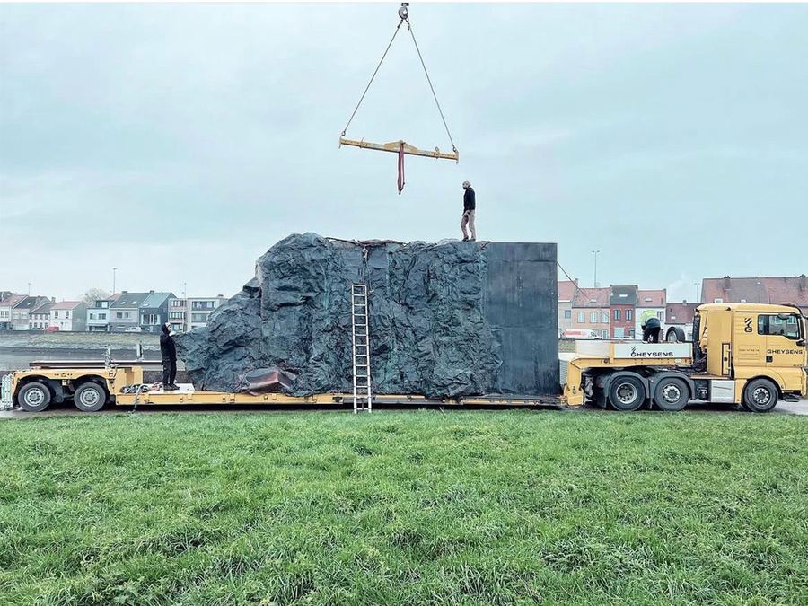 Large decorative boulder prop being lifted onto a low-loader trailer