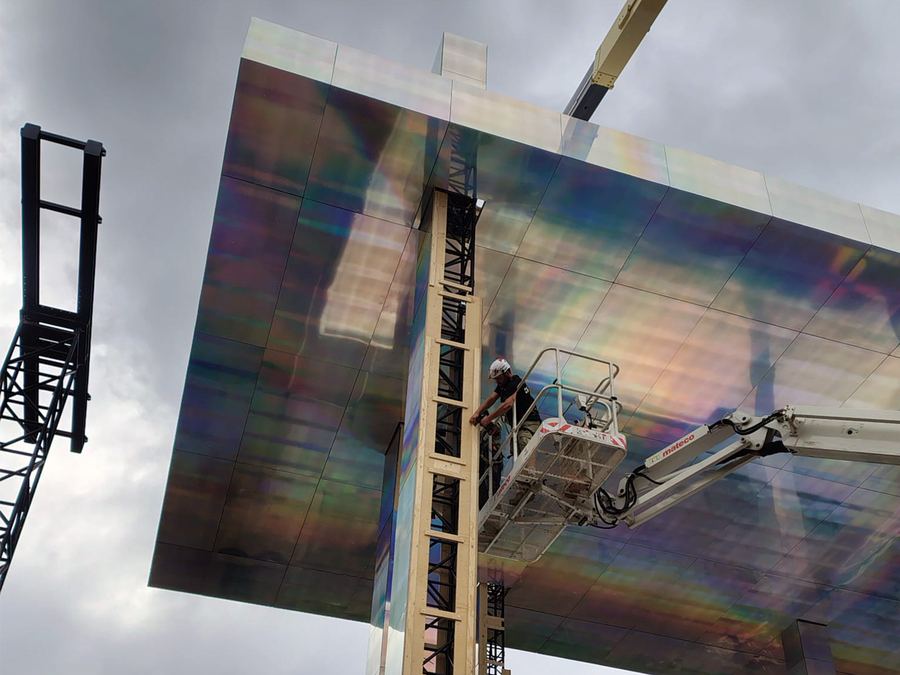 Rigger on a cherry picker installing an iridescent panel roof