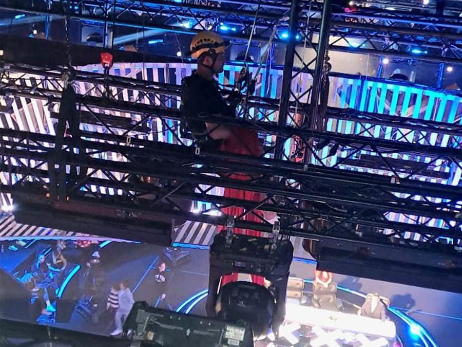 Rigger suspended above a TV talent-show set