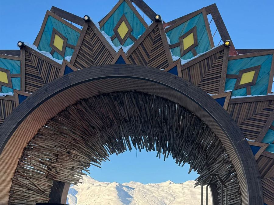 Decorative wooden archway stage with snow-capped mountains